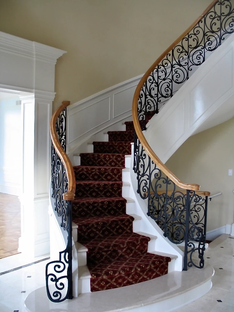 Curved staircase with handcrafted ornamental ironwork