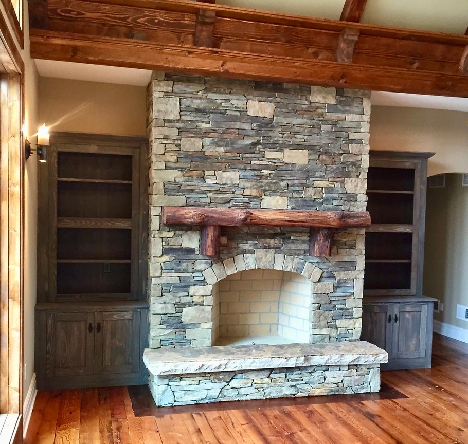 Custom stone fireplace with timber mantel and built-in cabinetry